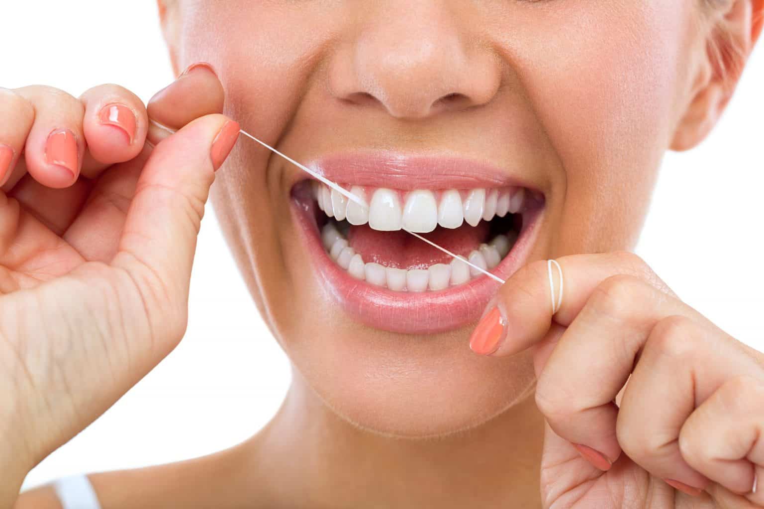Lady flossing her teeth and gums